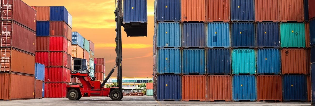 Ein roter Gabelstapler vor einem hohen Containerstapel © iStock/bugphai Ein roter Gabelstapler vor einem hohen Containerstapel © iStock/bugphai
