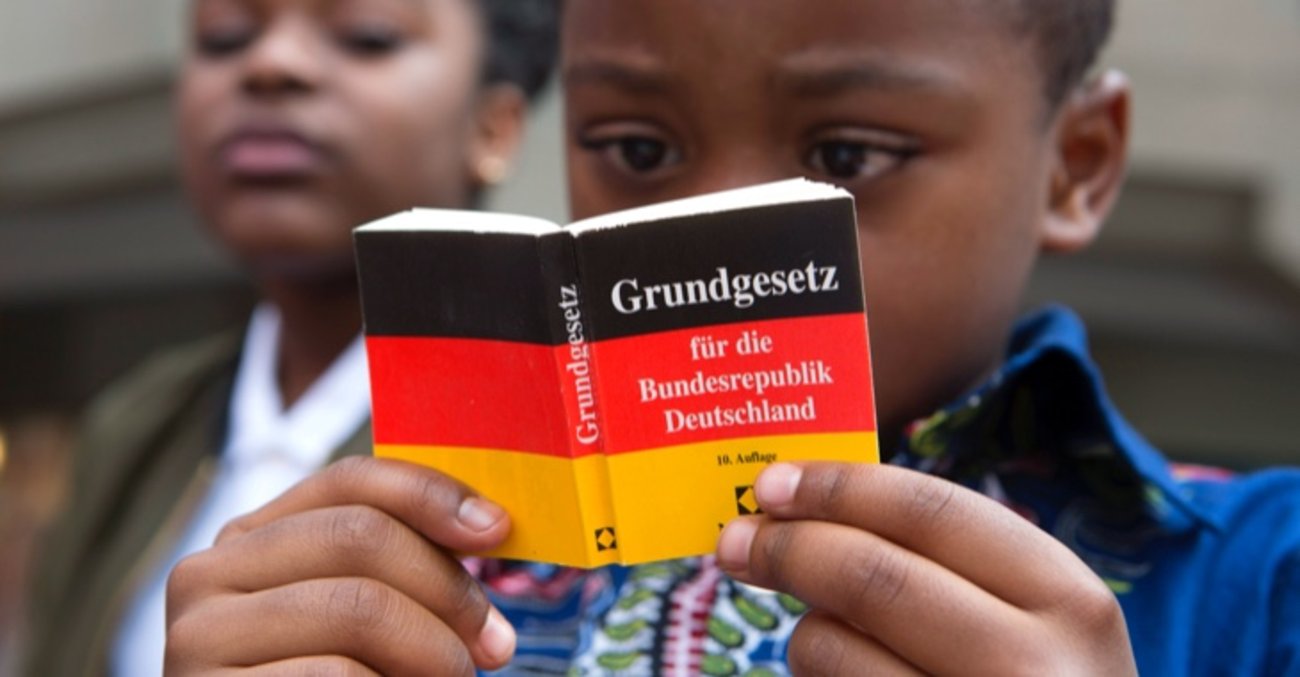 Ein Junge liest im Grundgesetz © picture alliance/Ulrich Baumgarten