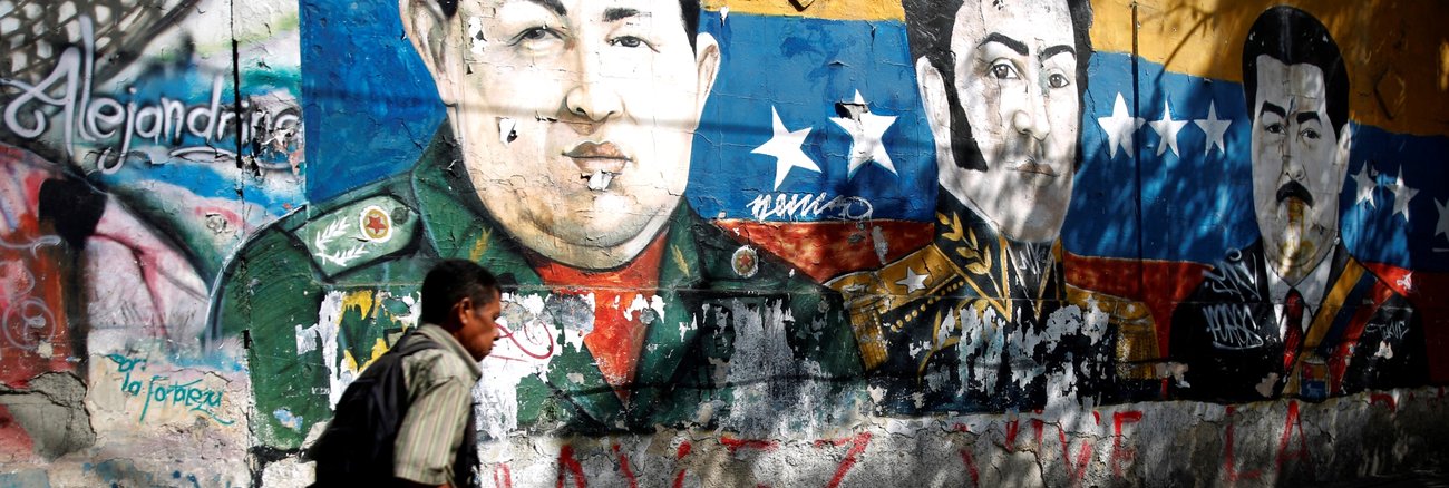 Ein Mann läuft am 30. Januar 2019 in Caracas, der Hauptstadt von Venezuela, an einem Graffiti vorbei, das die Köpfe von Hugo Chavez, Simon Bolivar und Nicolas Maduro zeigt © REUTERS/Carlos Barria Ein Mann läuft am 30. Januar 2019 in Caracas, der Hauptstadt von Venezuela, an einem Graffiti vorbei, das die Köpfe von Hugo Chavez, Simon Bolivar und Nicolas Maduro zeigt © REUTERS/Carlos Barria