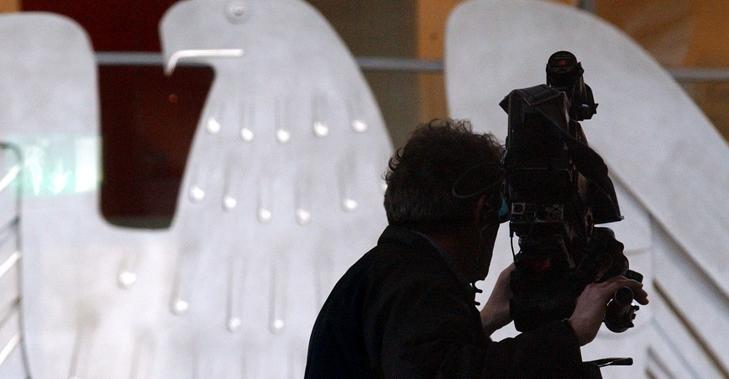 Silhouette eines Kameramanns mit Kamera vor dem Bundesadler im Plenarsaal des Bundestages © DBT/Hans-Günther Oed