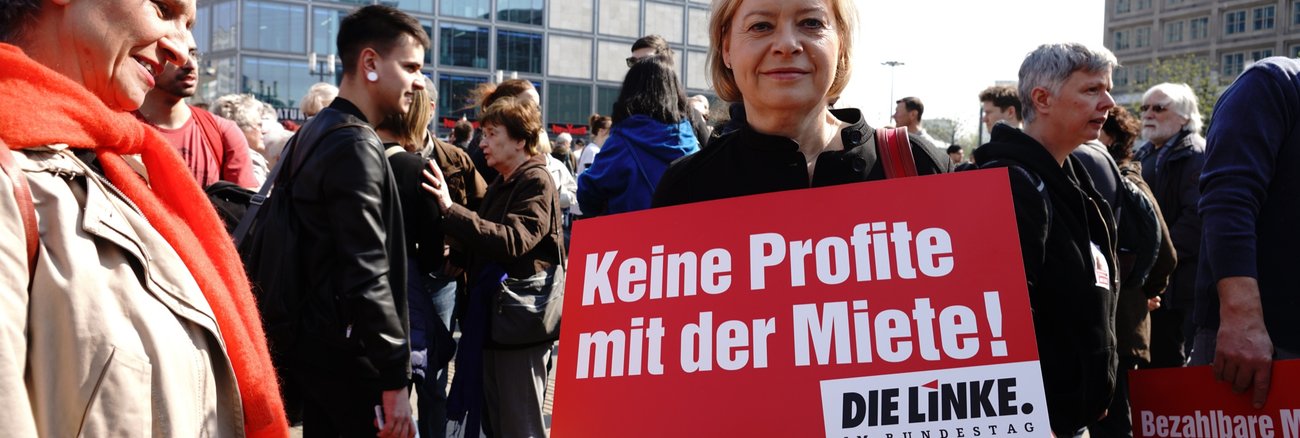 Gesine Lötzsch hält ein Schild mit der Aufschrift »Keine Profite mit der Miete!«