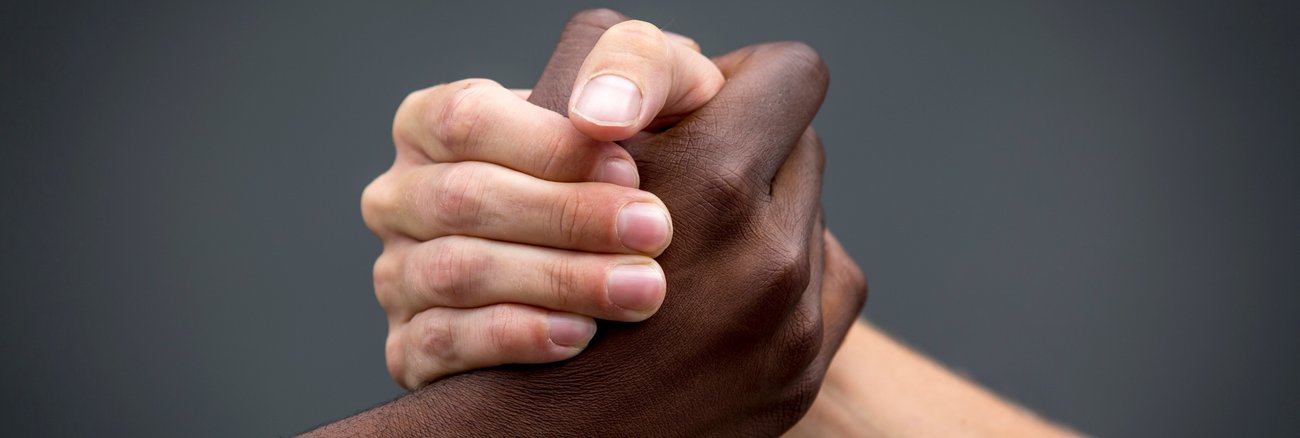 Fester Handschlag zwischen schwarzer und weißer Hand © iStock/JimmyLung Fester Handschlag zwischen schwarzer und weißer Hand © iStock/JimmyLung