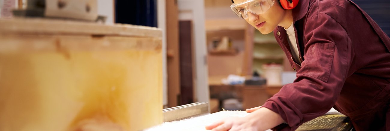 Junge Arbeiterin sägt Holzleisten an einer Kreissäge © iStockphoto.com/monkeybusinessimages