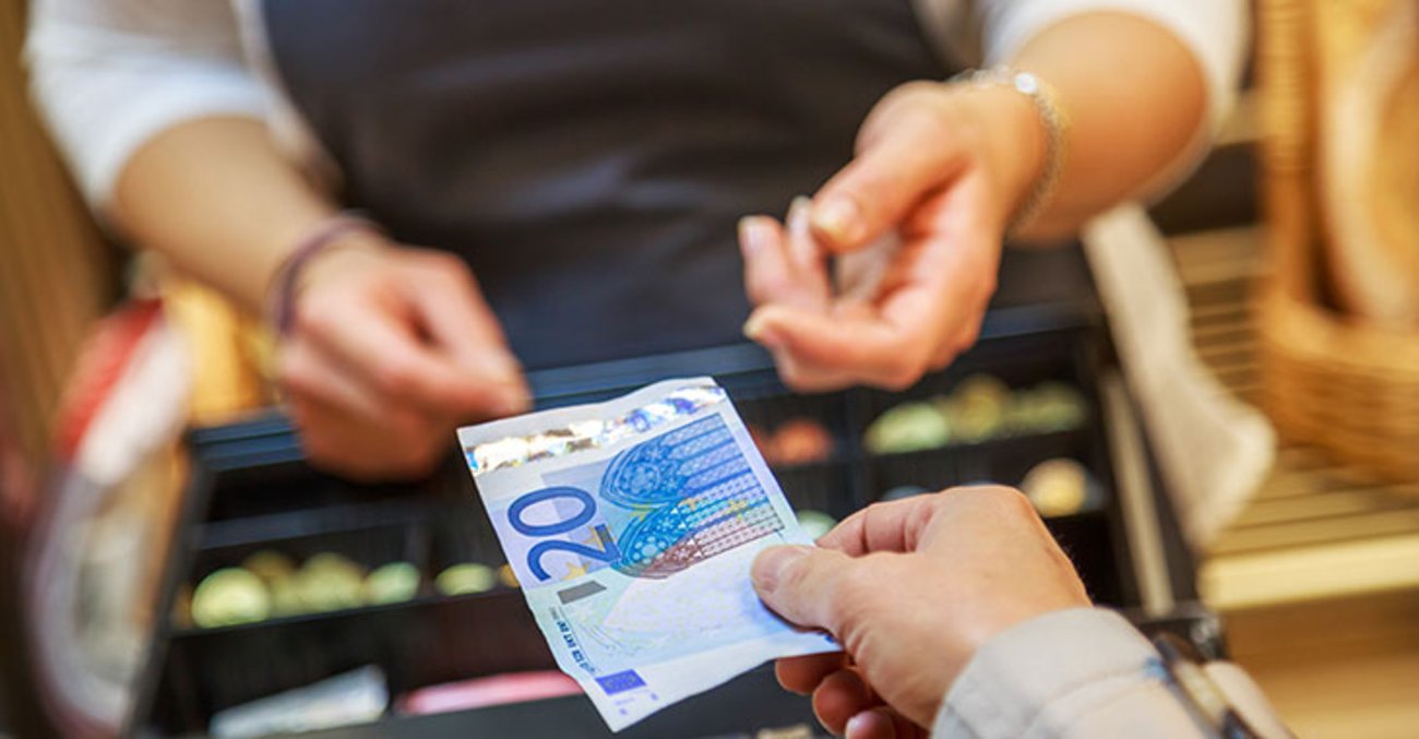 Einzelhandel: Geld wechselt den Besitzer an der Kasse in einem Supermarkt