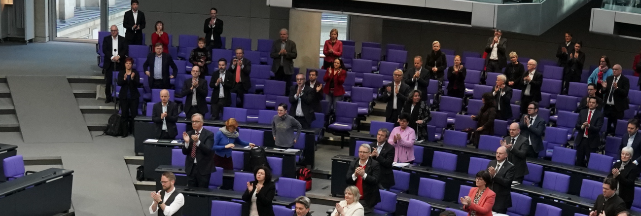 Die Mitglieder des Bundestages erheben sich am 25. März 2020 von ihren Plätzen und applaudieren als Zeichen des Danks an alle Helfer in der Coronakrise