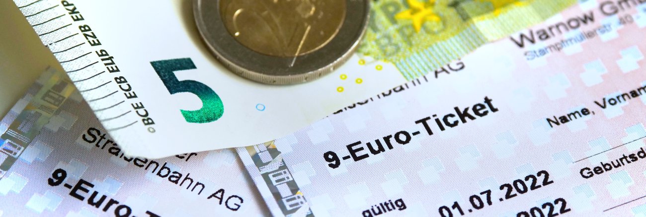 Mehrere 9-Euro-Tickets, ein 5-Euro-Schein und zwei 2-Euro-Münzen © iStock/ Eplisterra