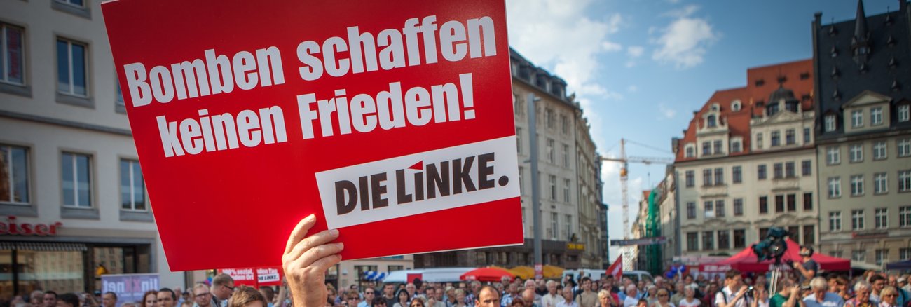 Bei einer Kundgebung in Leipzi hält ein Mann ein Schild mit der Aufschrift »Bomben schaffen keinen Frieden! DIE LINKE« © Jakob Huber Bei einer Kundgebung in Leipzi hält ein Mann ein Schild mit der Aufschrift »Bomben schaffen keinen Frieden! DIE LINKE« © Jakob Huber