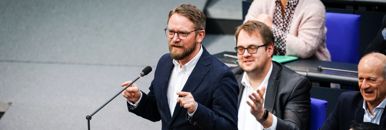 Jan Korte am Mikrofon an seinem Platz in den Fraktionsreihen der Linksfraktion im Plenarsaal des Bundestages