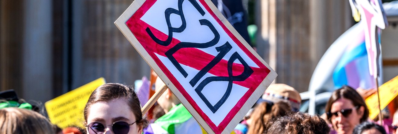 Eine Frau hält ein Schild, auf dem Paragraf 218 durchgestrichen ist © picture alliance/Bahho Kara/Kirchner-Media
