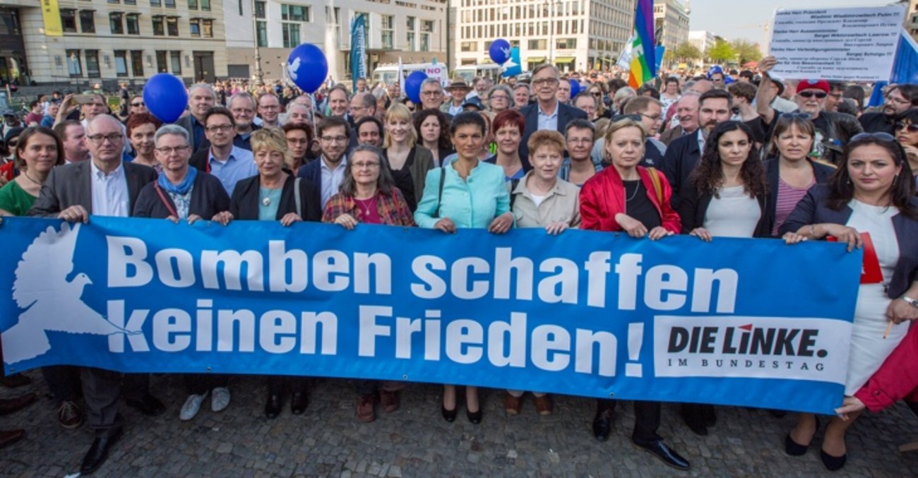 Bei der Friedenskundgebung am 18. April 2018 am Brandenburger Tor in Berlin für Deeskalation in Syrien halten Mitglieder der Linksfraktion ein Transparent mit der Aufschrift: Bomben schaffen keinen Frieden!