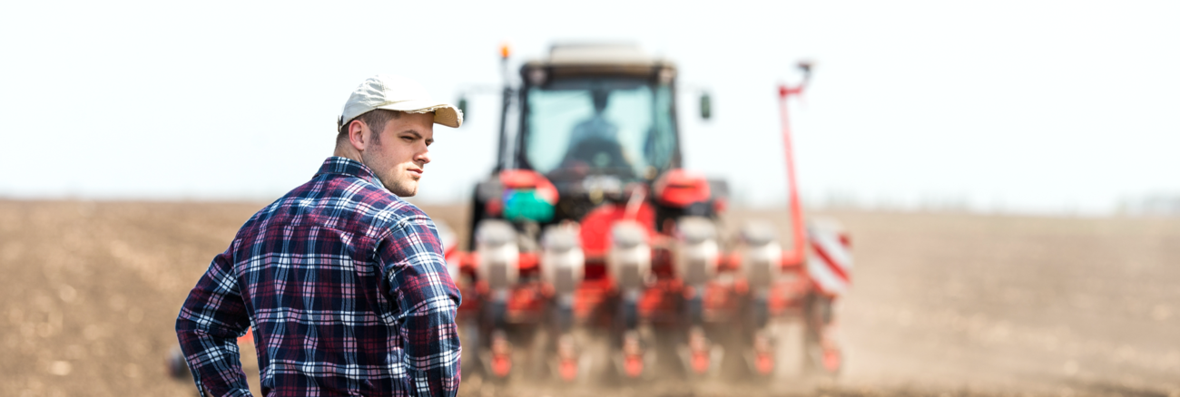 Junger Bauer auf einem Acker hinter einem Traktor bei der Aussaat © iStock/fotokostic Junger Bauer auf einem Acker hinter einem Traktor bei der Aussaat © iStock/fotokostic
