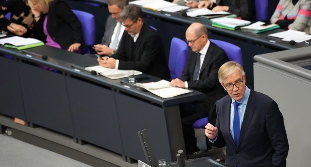 Dietmar Bartsch am Rednerpult des Bundestages, dahinter auf der Regierungsbank Bundeskanzler Olaf Scholz, Robert Habeck und Christian Lindner Dietmar Bartsch am Rednerpult des Bundestages, dahinter auf der Regierungsbank Bundeskanzler Olaf Scholz, Robert Habeck und Christian Lindner