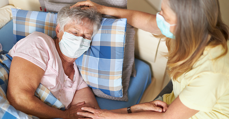 Eine Angehörige pflegt eine ältere Frau zu Hause. © istock.com/2K Studio