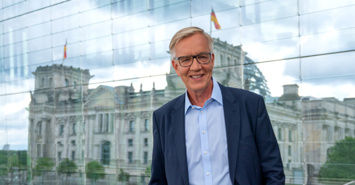 Dietmar Bartsch vor einer Glaswand, in der sich der Reichstag spiegelt © picture alliance/dpa | Christophe Gateau