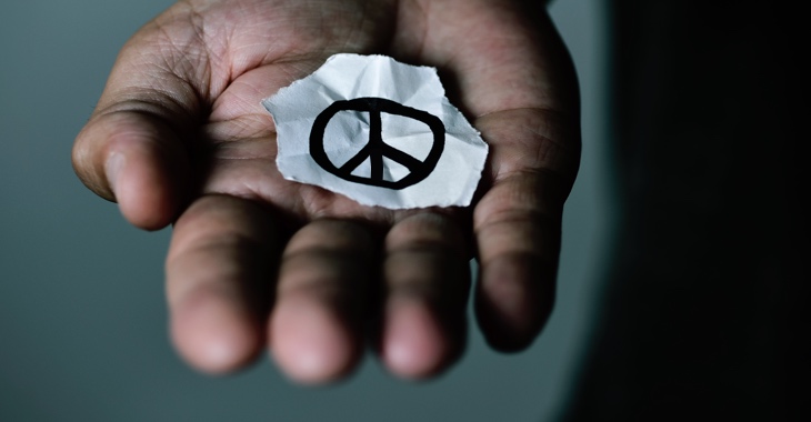 Das CND-Friedenssymbol auf einem abgerissenen Papier in einer aufgehaltenen Hand © iStockphoto.com/nito100 Das CND-Friedenssymbol auf einem abgerissenen Papier in einer aufgehaltenen Hand © iStockphoto.com/nito100