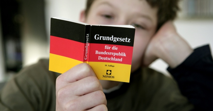 Ein Junge hält ein Grundegsetz @ dpa Ein Junge hält ein Grundegsetz @ dpa