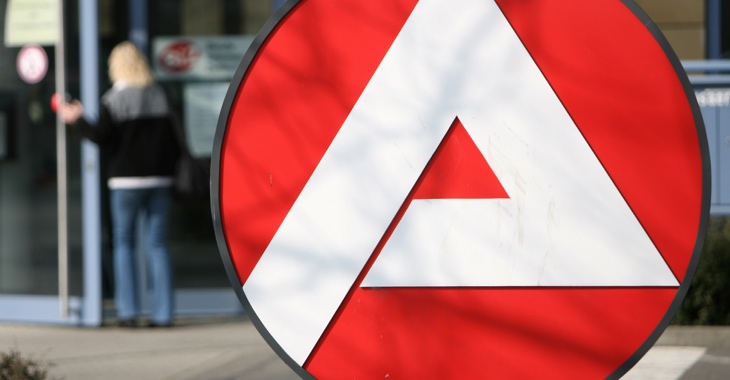 Logo der Agentur für Arbeit, dahinter verschwommen: eine Frau am Eingang eines Jobcenters © ddp images Logo der Agentur für Arbeit, dahinter verschwommen: eine Frau am Eingang eines Jobcenters © ddp images