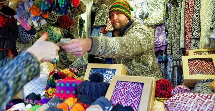 Marktverkäufer mit Strickwaren reicht einer Frau einen Euro-Schein © iStockphoto.com/Roman Babakin Marktverkäufer mit Strickwaren reicht einer Frau einen Euro-Schein © iStockphoto.com/Roman Babakin