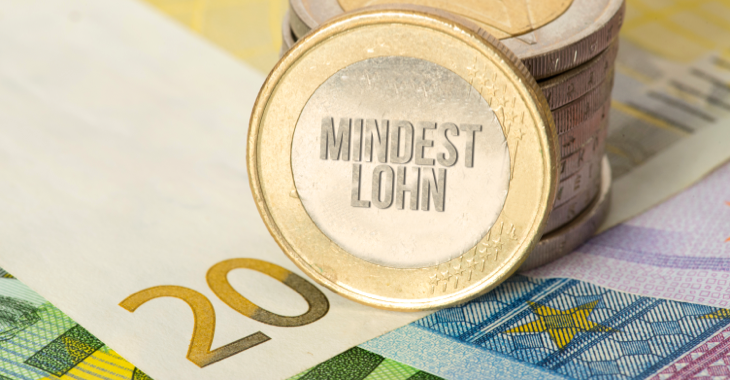 An einen Stapel Euro-Münzen ist eine gangelehnt mit der Aufschrift Mindestlohn © iStock/Stadtratte An einen Stapel Euro-Münzen ist eine gangelehnt mit der Aufschrift Mindestlohn © iStock/Stadtratte