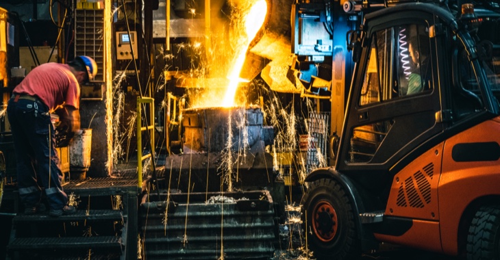 In einem Stahlwerk wird geschmolzenes Metall in eine Gießform gegossen, daneben eine Arbeiter und ein Gabelstapler © iStock/simonkr In einem Stahlwerk wird geschmolzenes Metall in eine Gießform gegossen, daneben eine Arbeiter und ein Gabelstapler © iStock/simonkr