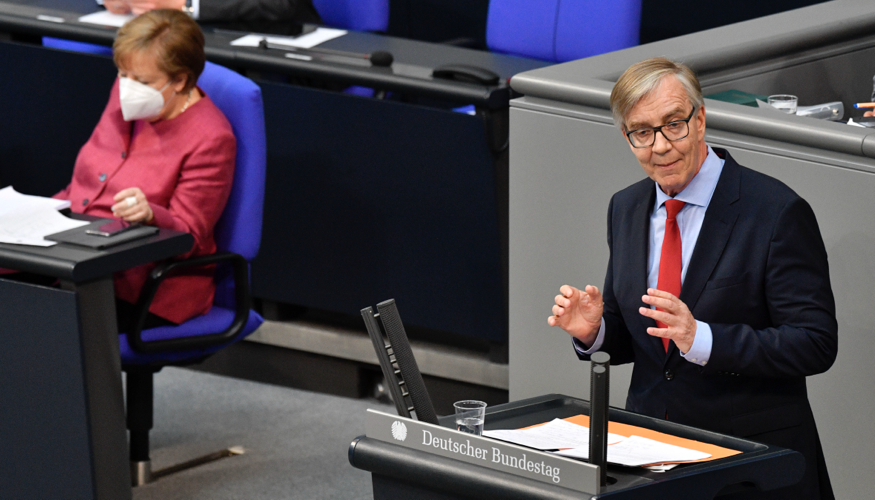 Dietmar Bartsch am Rednerpult des Bundestages, dahinert Bundeskanzlerin Merkel mit Maske auf der Regierungsbank © picture alliance/Geisler-Fotopress/Frederic Kern/Geisler-Fotopress Dietmar Bartsch am Rednerpult des Bundestages, dahinert Bundeskanzlerin Merkel mit Maske auf der Regierungsbank © picture alliance/Geisler-Fotopress/Frederic Kern/Geisler-Fotopress