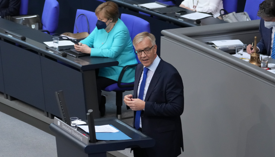 Dietmar Bartsch am Rednerpult des Bundestages, dahinter Bundeskanzlerin Merkel auf der Regierungsbank
